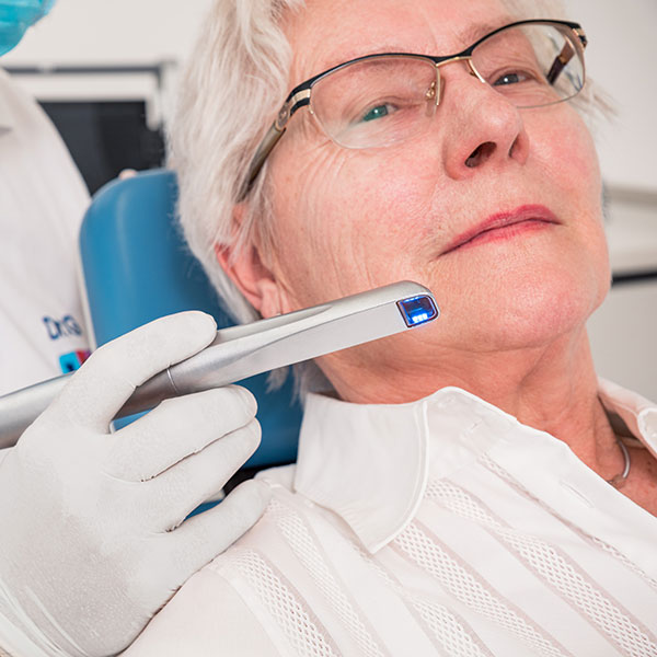 Zahnarztpraxis Dachau - Dr. Gitt behandelt mit dem Intraoralscanner Dr. Gitt behandelt eine Seniorin mit dem Intraoralscanner in seiner Zahnarztpraxis in Dachau.