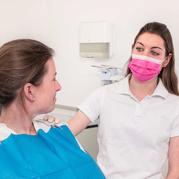 Familienzahnarzt-Dr.-Gitt---Schmerzpatienten-quad Assistentin beruhigt eine Schmerzpatientin.