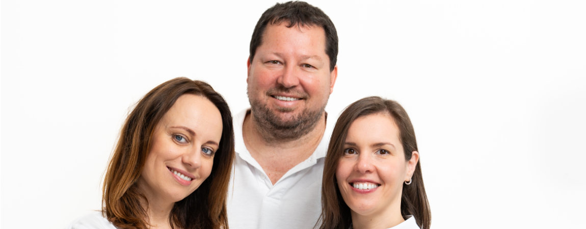 Aerzteteam 2 Dr. Gitte, Zahnarzt in Dachau, mit seinen beiden Zahnärztinnen, alle lächelnd.