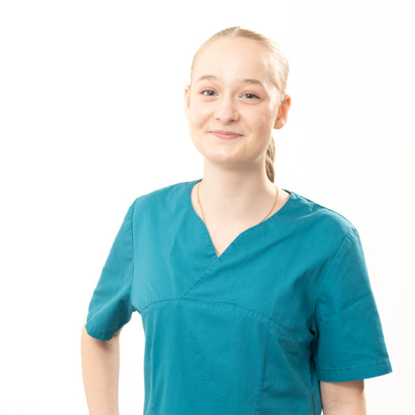 Natalie Auszubildende Natalie im petrolfarbenen Kittel mit Pferdeschwanz