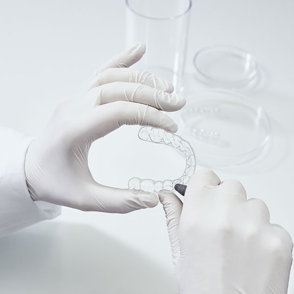 Dr. Gitt bearbeitet eine Zahnschiene von DrSmile Dachau